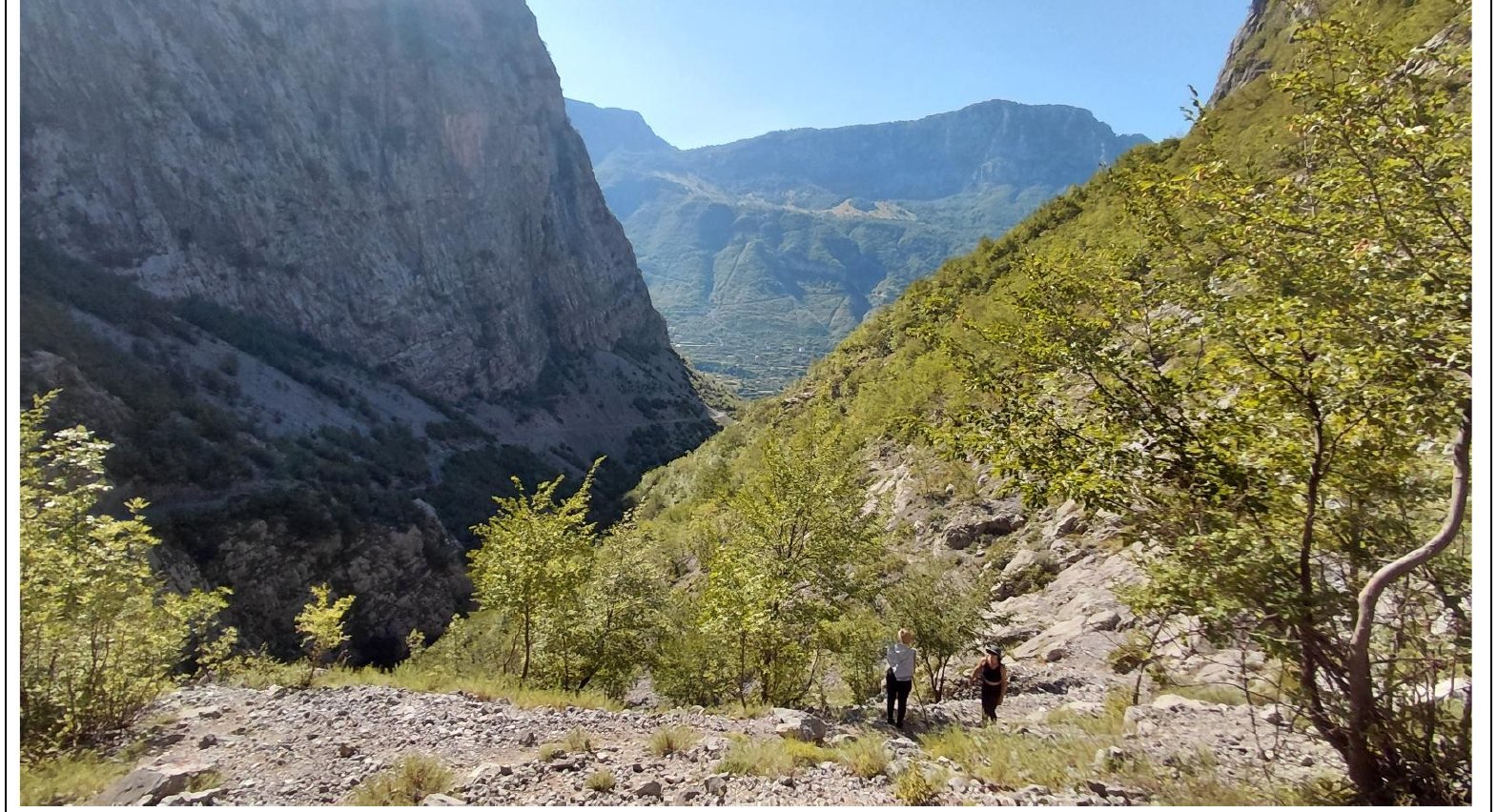Hikers descending a rocky canyon trail near Selcë
