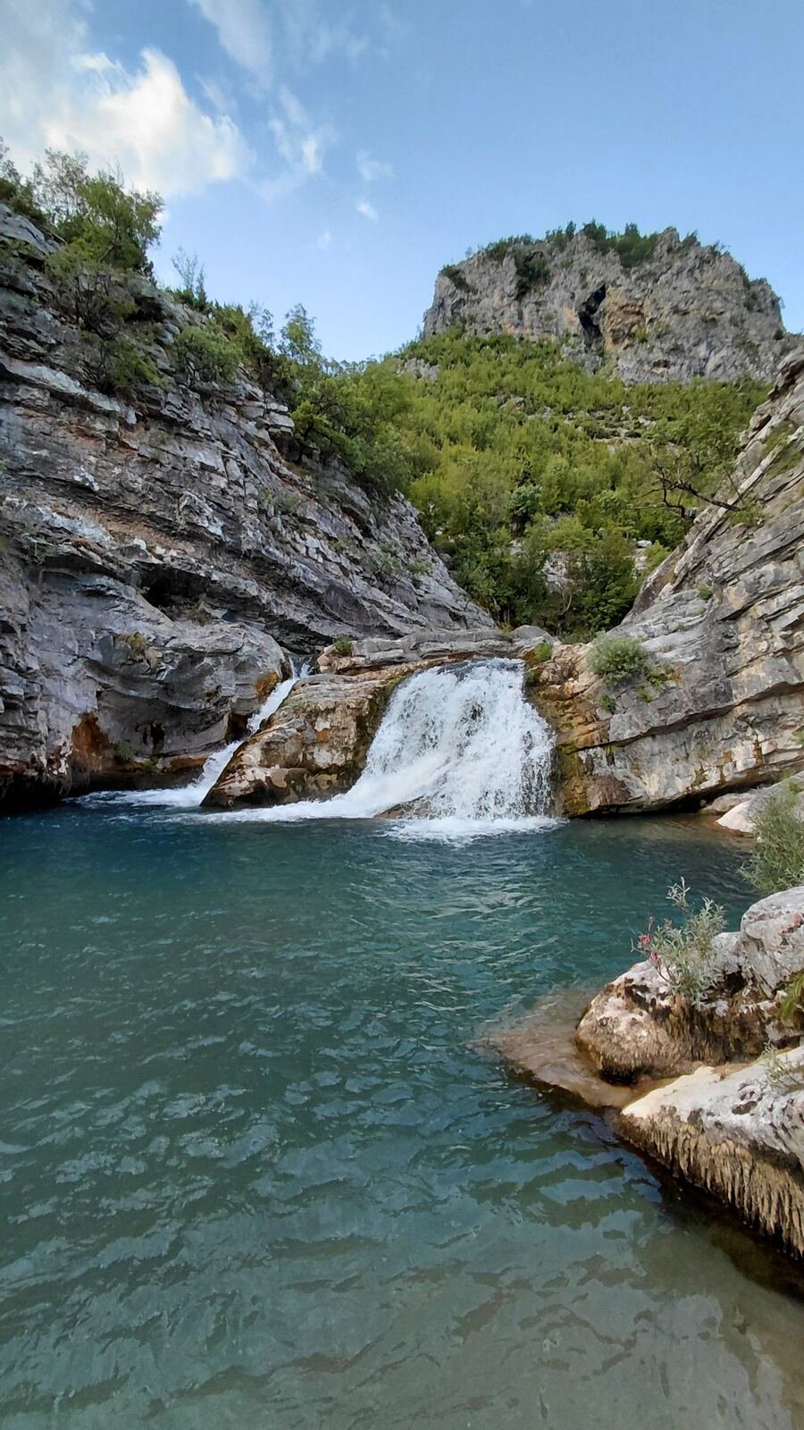 Waterfall dropping into a turquoise pool near Selcë, Kelmend